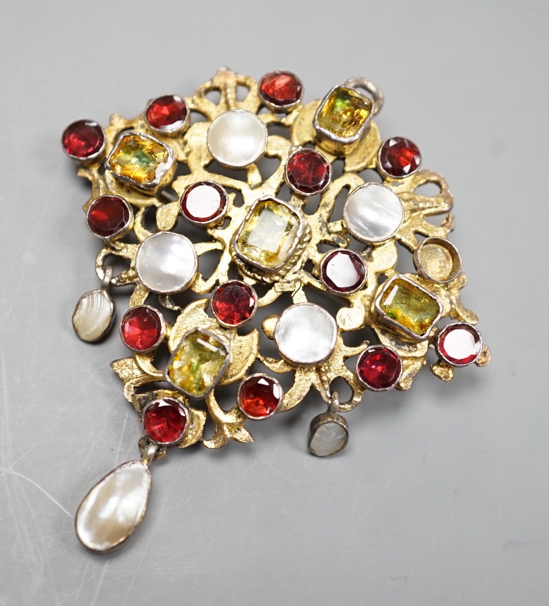 An Indian? gilt white metal and multi gem set drop pendant brooch, (stone missing), 54mm.